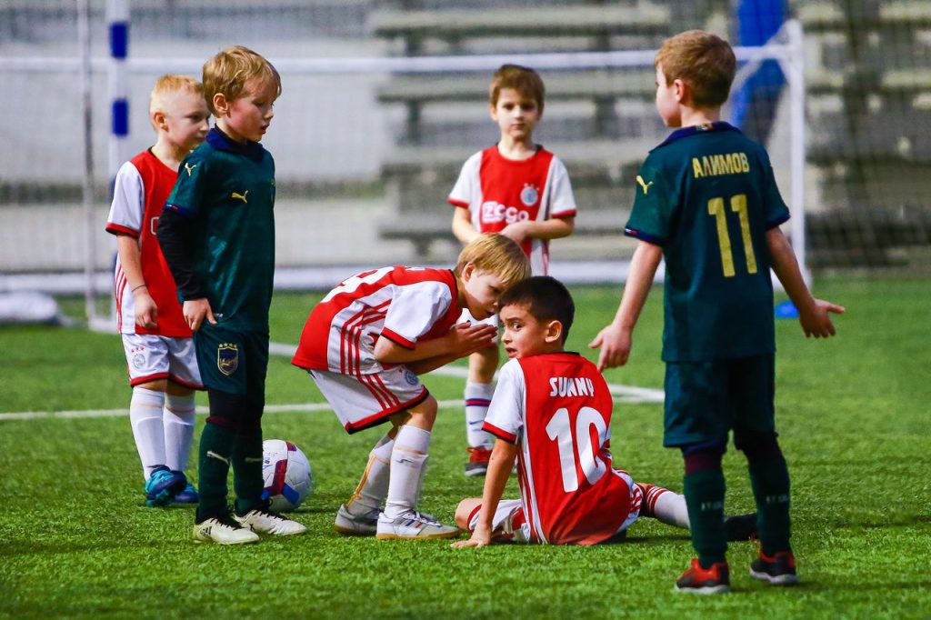 Kids engaged in a soccer game on an indoor field, showcasing teamwork.